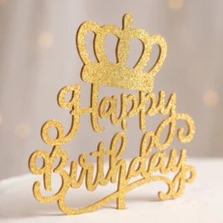 ettaglio del cake topper Happy Birthday con corona in oro glitter su torta bianca